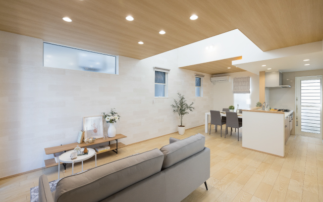 光が降り注ぐ吹き抜けリビングの家の画像